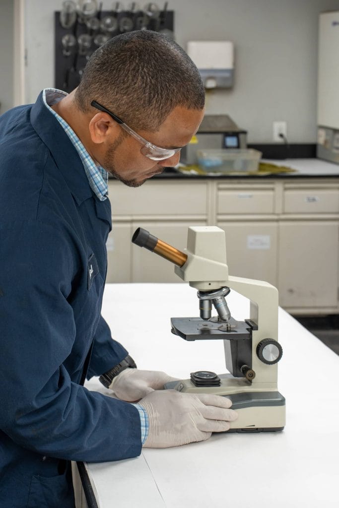 Chemist examining a sample under a microscope