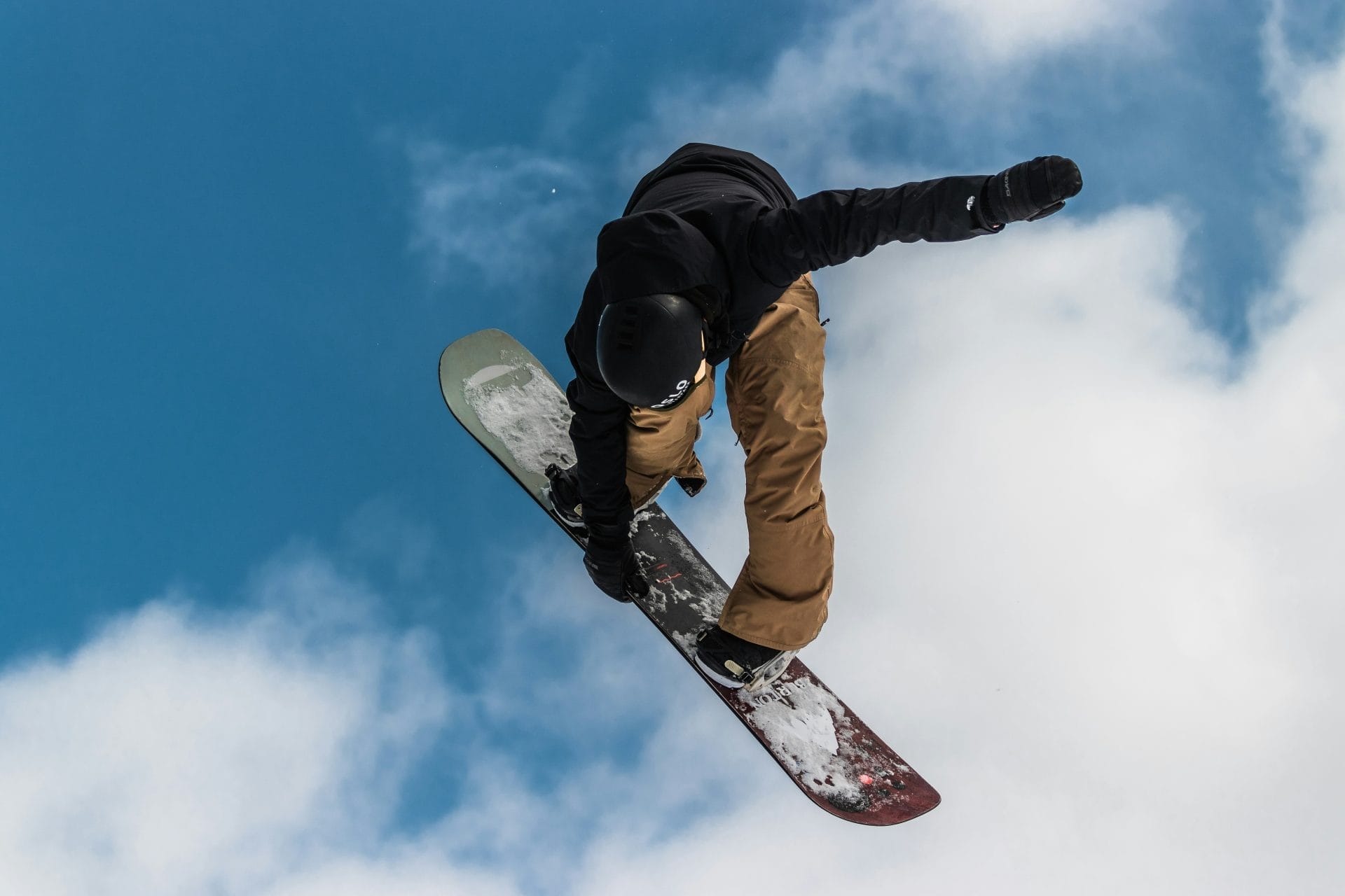 Snowboarder in mid-air against a blue sky